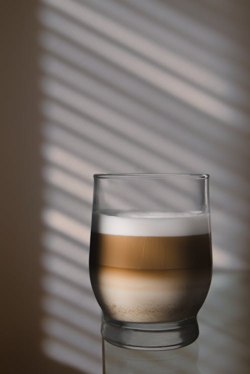 A glass of coffee with a shadow on it