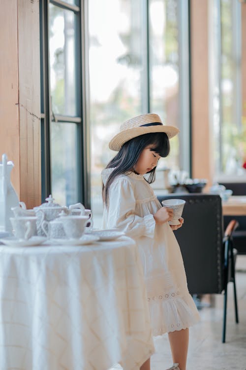 Girl in Hat and White Dress at Restaurant