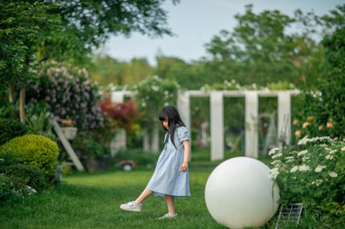 Girl in Blue Dress in Garden