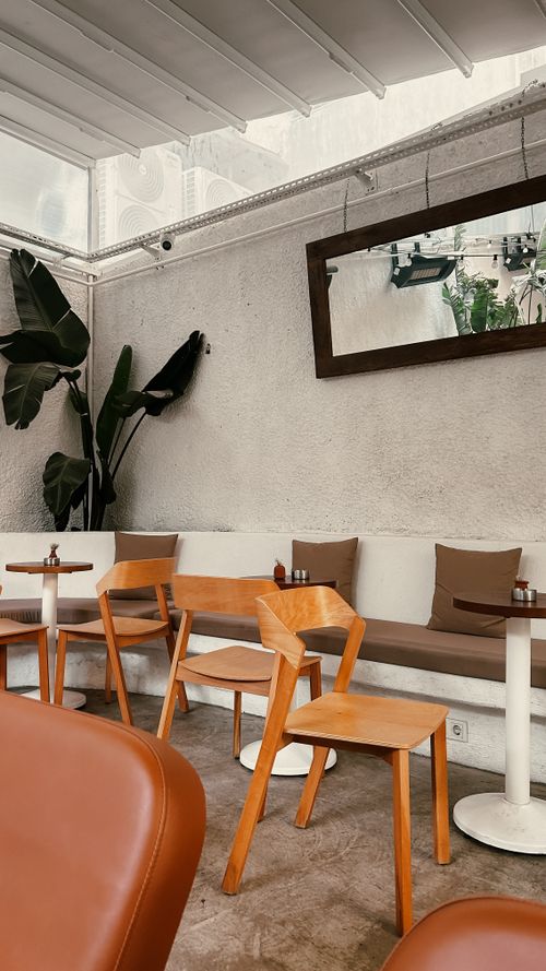 Free A stylish indoor cafe with wooden chairs, tables, and a cozy ambiance, perfect for casual dining. Stock Photo