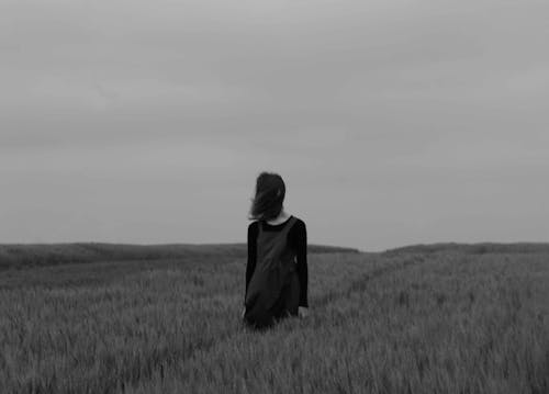 Woman Standing Between Grass Grayscale Photography