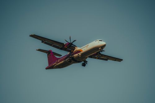 Free A commercial propeller airplane flying in a clear sky, captured from a low angle. Stock Photo