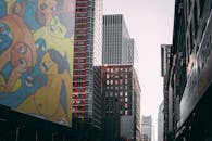 城市天际线以现代摩天大楼和黄昏时充满活力的壁画为特色，展现了城市的艺术风貌