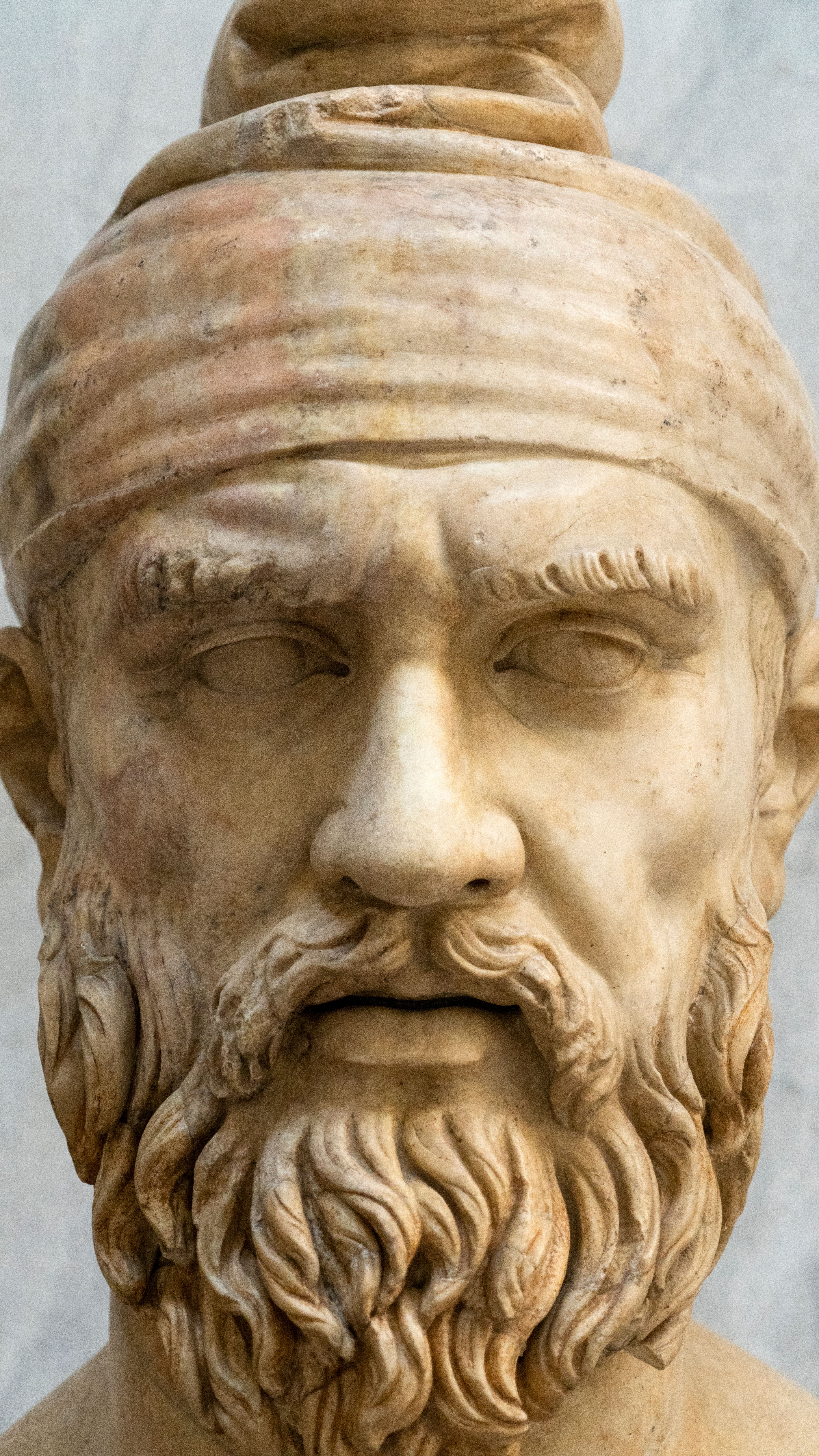 Close-up view of a detailed marble sculpture with a beard and headwear.