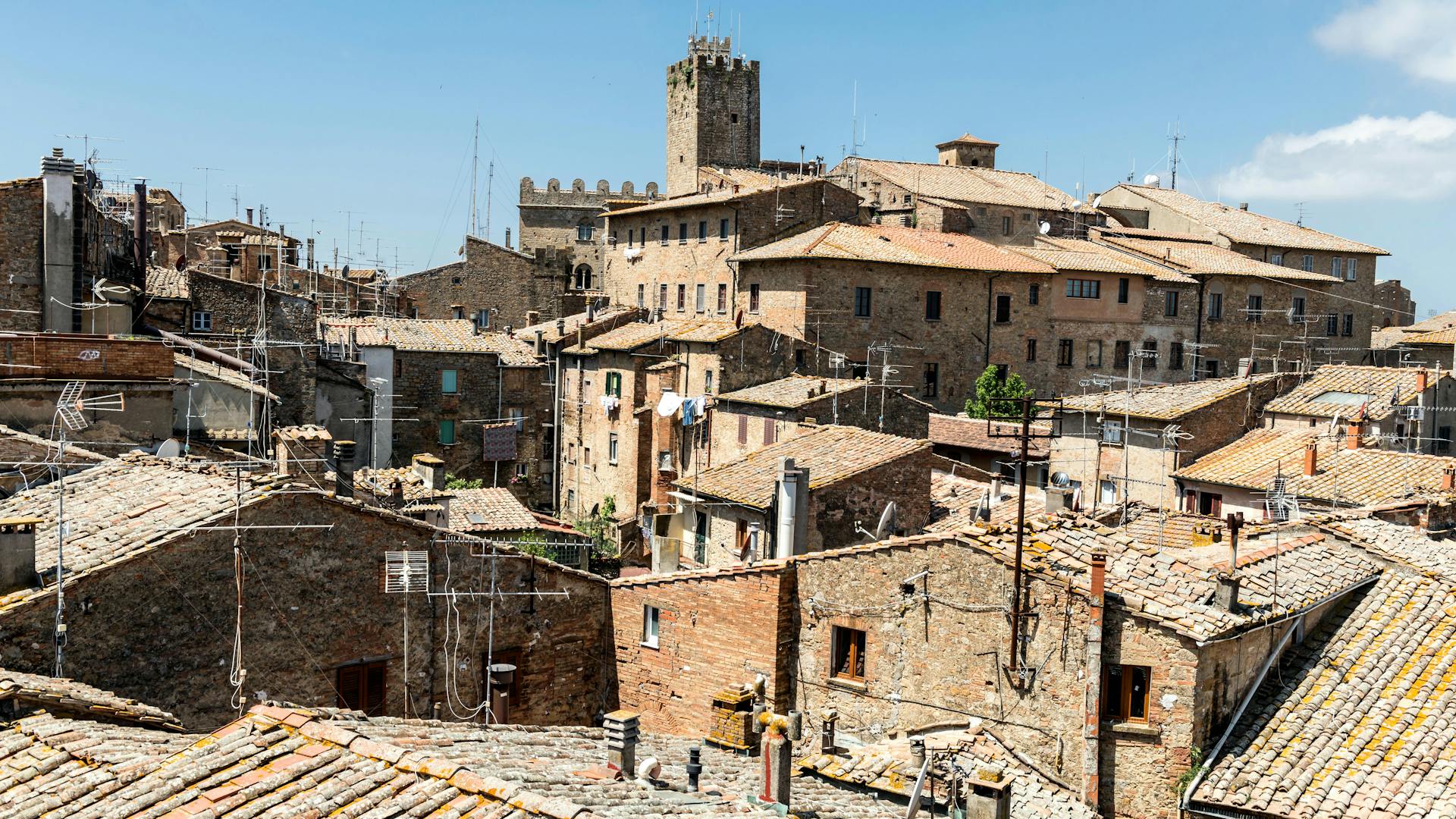 Scenic view of medieval rooftops in Volterra, Tuscany under a clear blue sky.