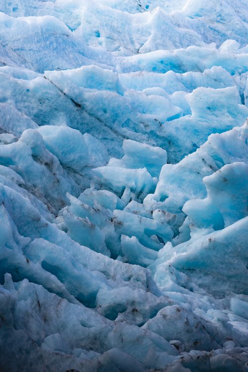 Free Stunning vertical shot of a glacier's blue ice formations, highlighting the effects of climate change and melting ice. Stock Photo