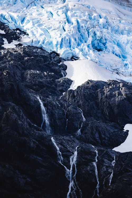 Free Stunning glacial scene with ice, snow, and waterfall on a rugged mountain landscape. Stock Photo