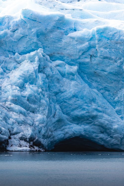 Free A breathtaking view of a blue glacier ice cave meeting the cold ocean waters. Stock Photo