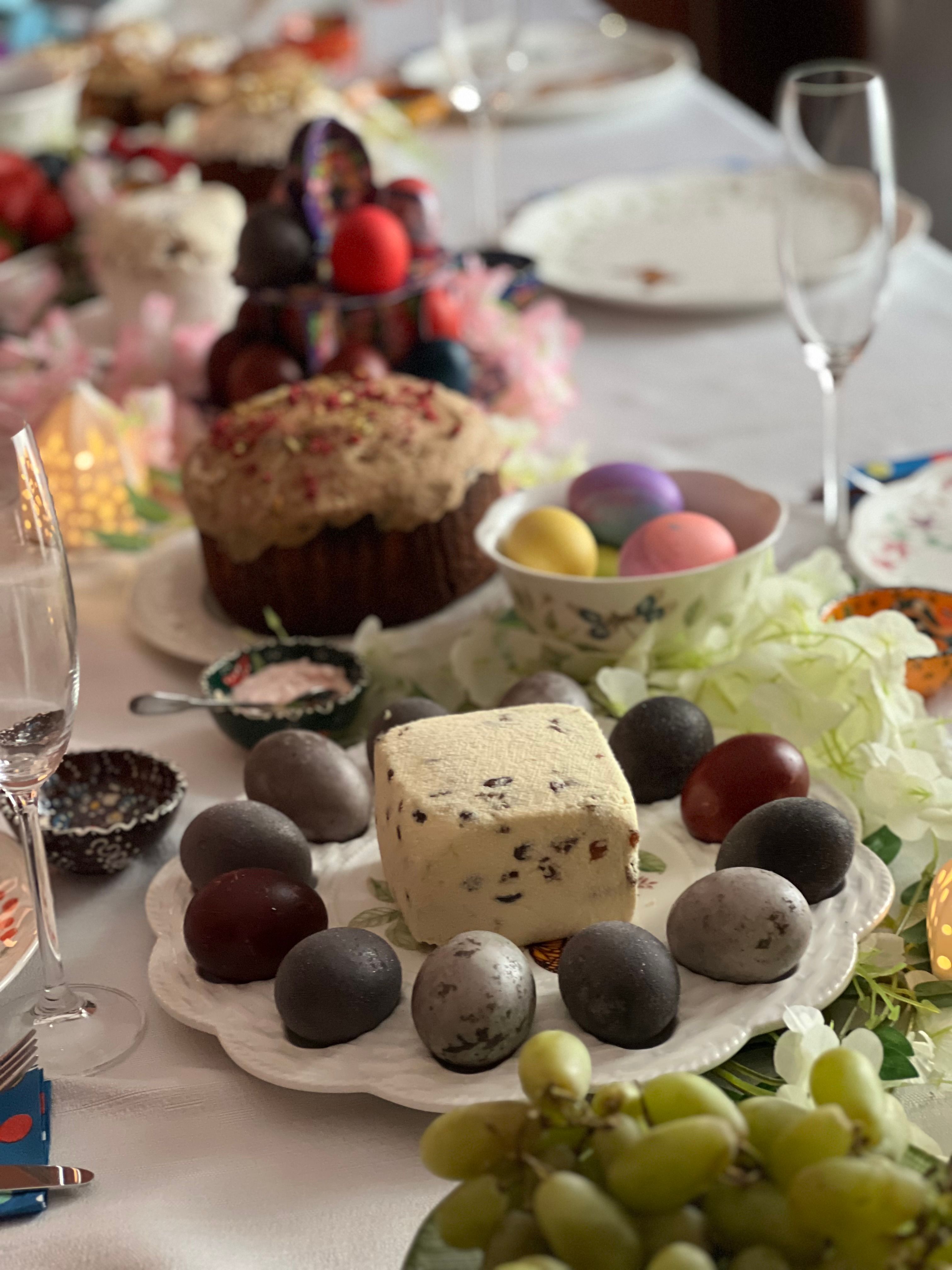 A delightful Easter table display featuring decorated eggs, traditional cake, and festive food items.