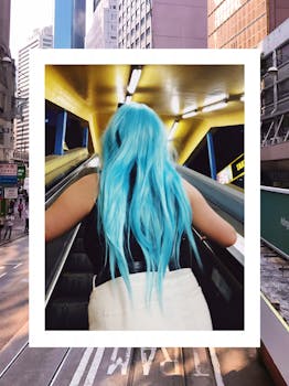 在现代城市环境中，一位蓝发女子乘坐着室内自动扶梯