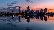 日落时分，维也纳城市景观的宁静倒影映照在平静的海水和绚烂的天空之中