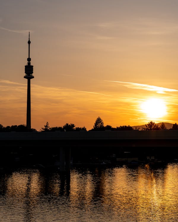 Free Silhouette of Tower Near Body of Water during Sunset Stock Photo