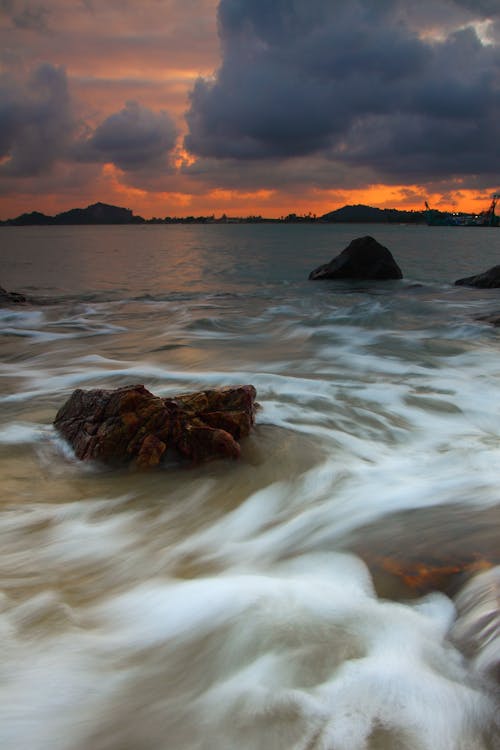 Ücretsiz Altın Saatte Denize Yakın Taşlar Stok Fotoğraflar