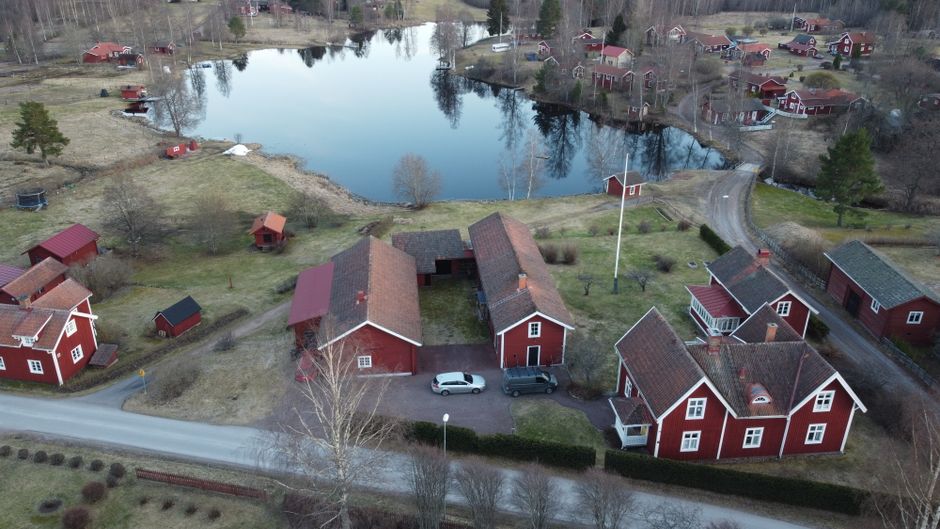 Charming aerial view of red houses by a lake in Dalarnas län, Sweden.