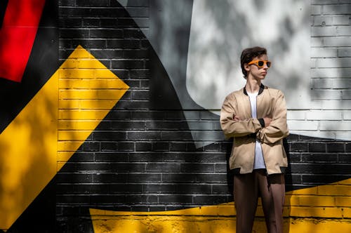 A man standing in front of a wall with a colorful mural