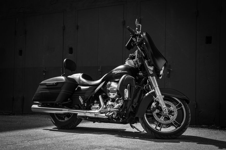 Black Harley-Davidson parked in a moody urban setting, showcasing classic design.