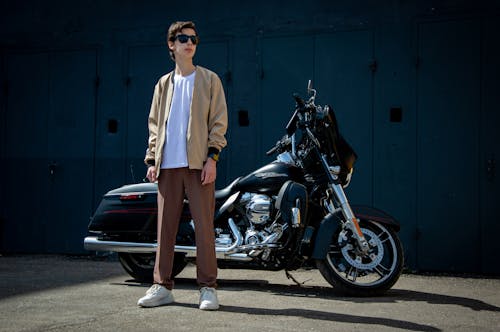 A man standing next to a black motorcycle