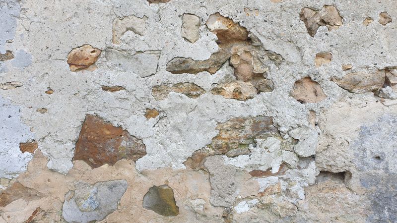 Façade en pierre et ciment patinée par l'humidité atlantique, à nettoyer
