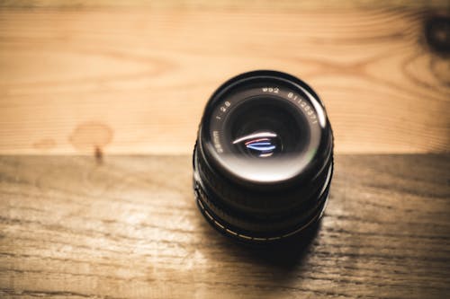 Black Camera Lens on Brown Wooden Table