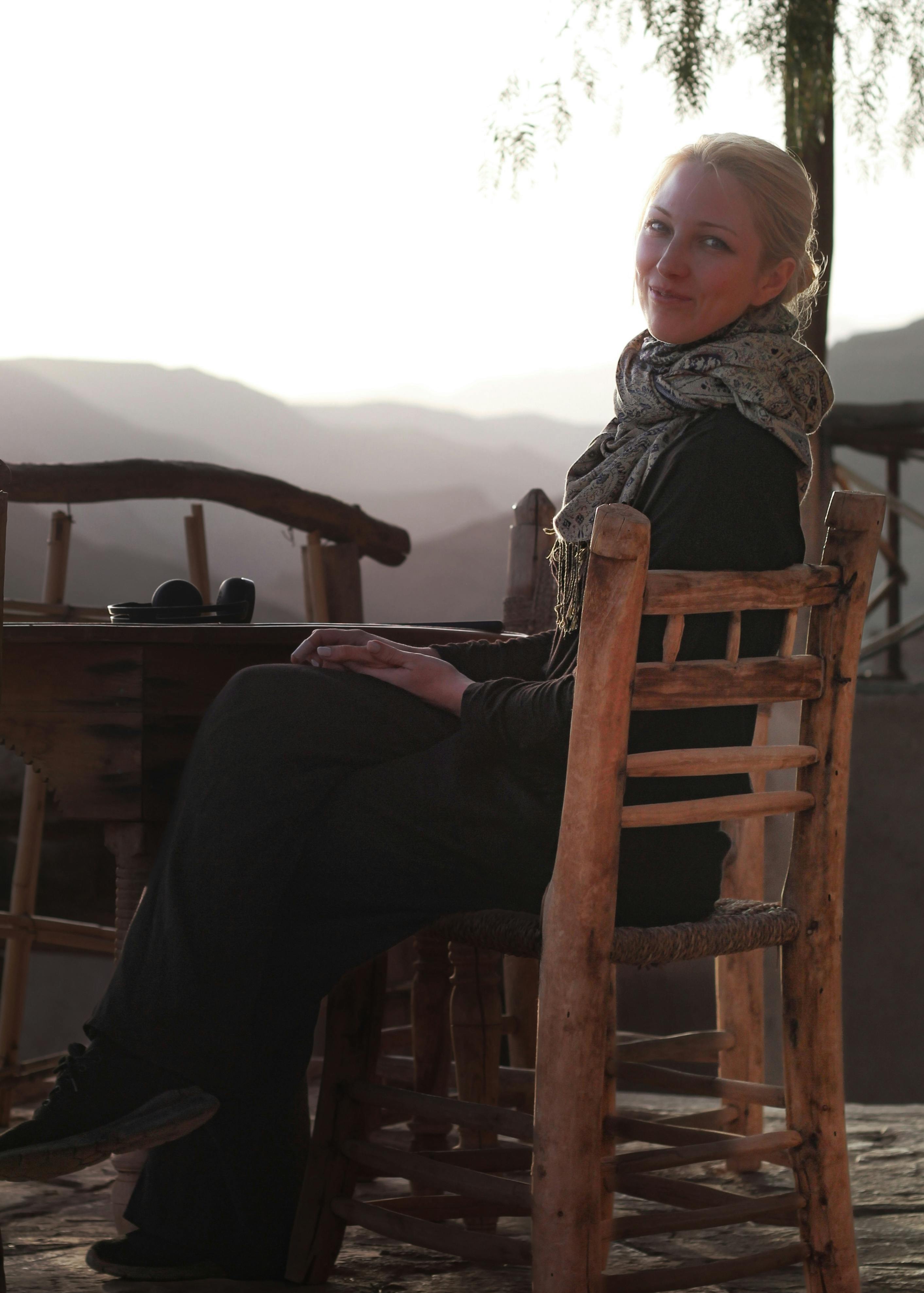 Caucasian woman enjoying a serene moment in the Moroccan mountains during a sunset.