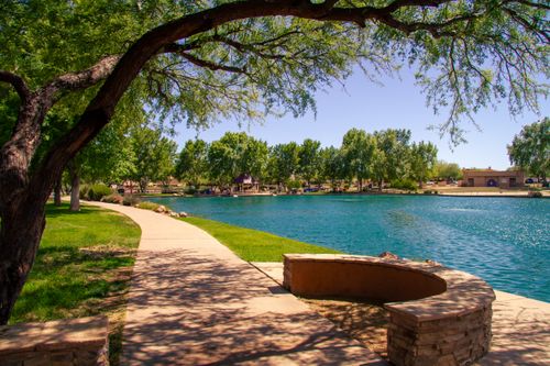 Free Explore a peaceful urban park with a scenic lake and lush greenery under a bright summer sky. Stock Photo