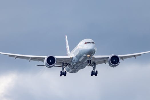 An airplane glides through a cloudy sky during approach and landing.