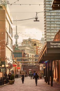 A vibrant street scene in Toronto with the iconic CN Tower visible, capturing urban life.