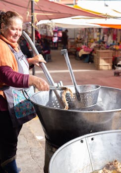 Woman cooking traditional Mexican street food at Canalejas market. Captured with vibrant mood.