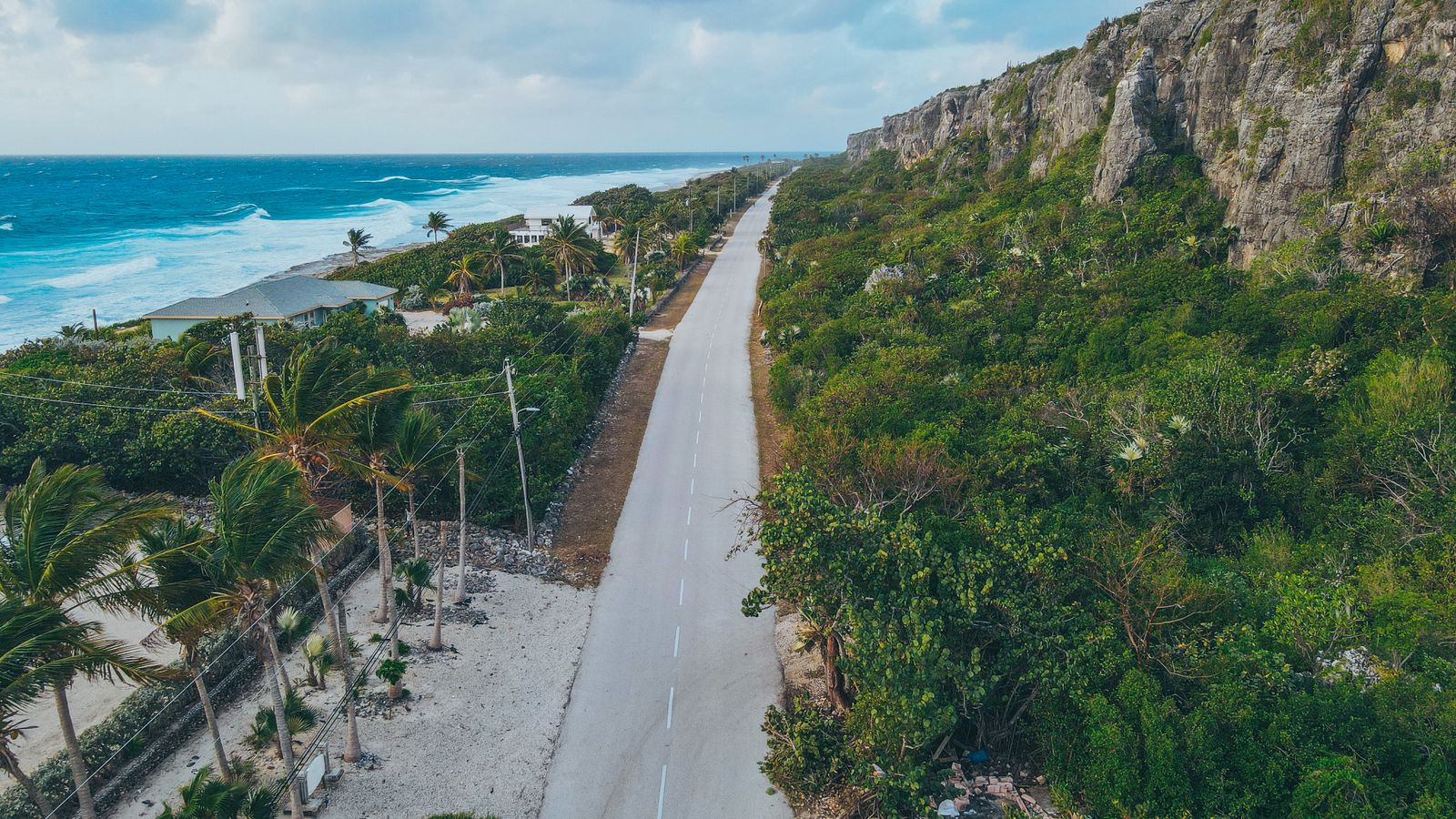 Aerial view showcasing the stunning coastline and road beside cliffs in Cayman Islands.