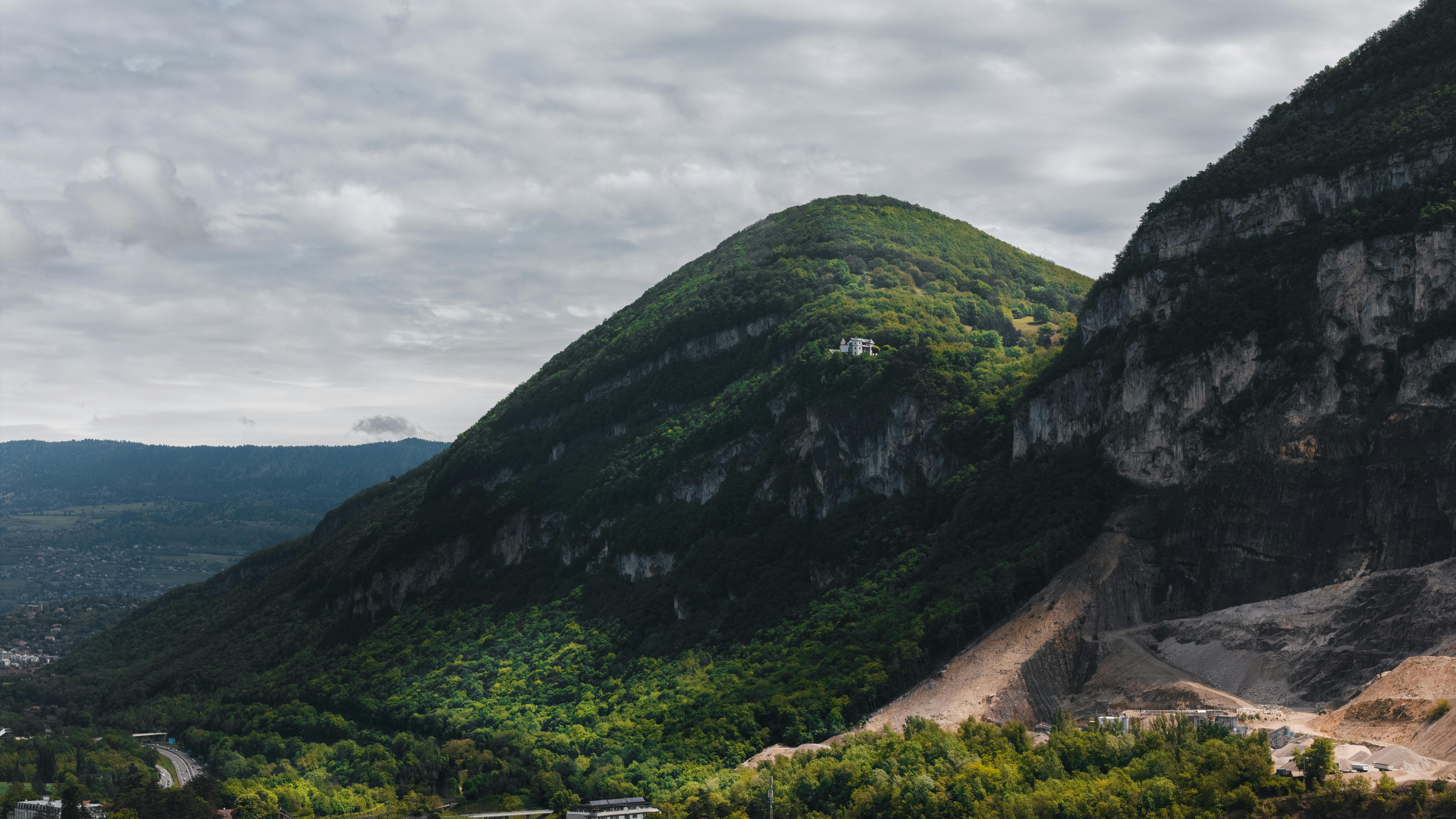 Breathtaking view of lush green mountains in Geneva with cloudy skies.