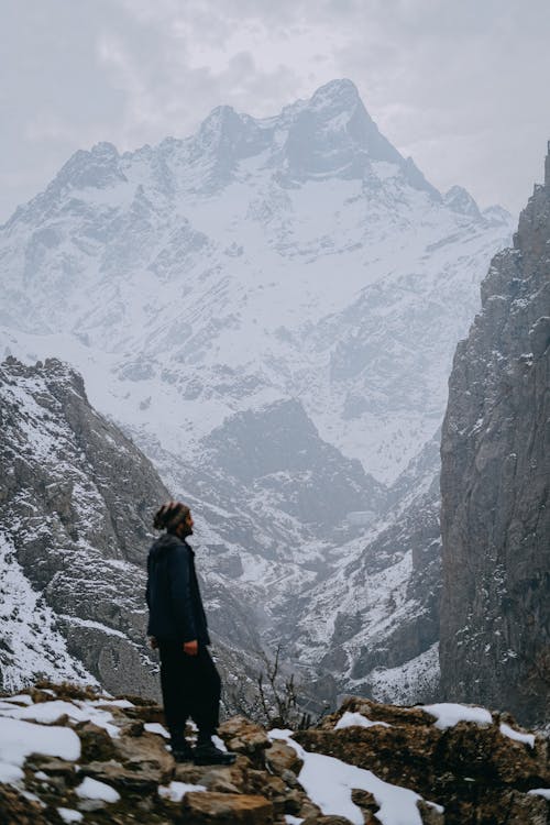 A man standing on a rock in the mountains