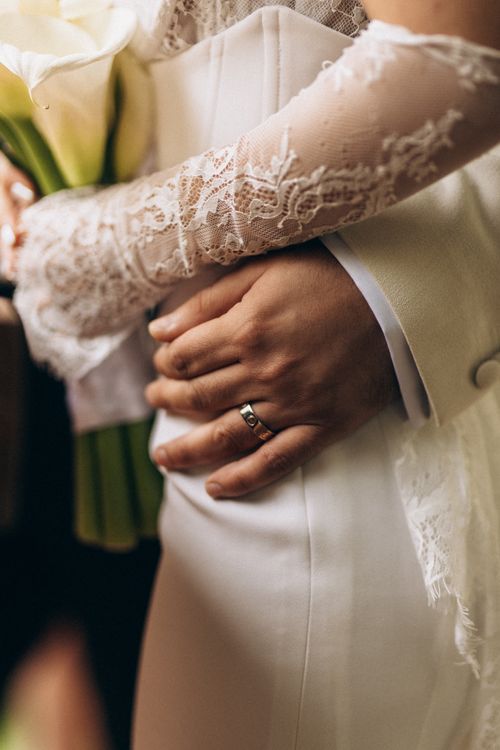 Free Close-up of a newlywed couple holding hands and a bouquet. Stock Photo