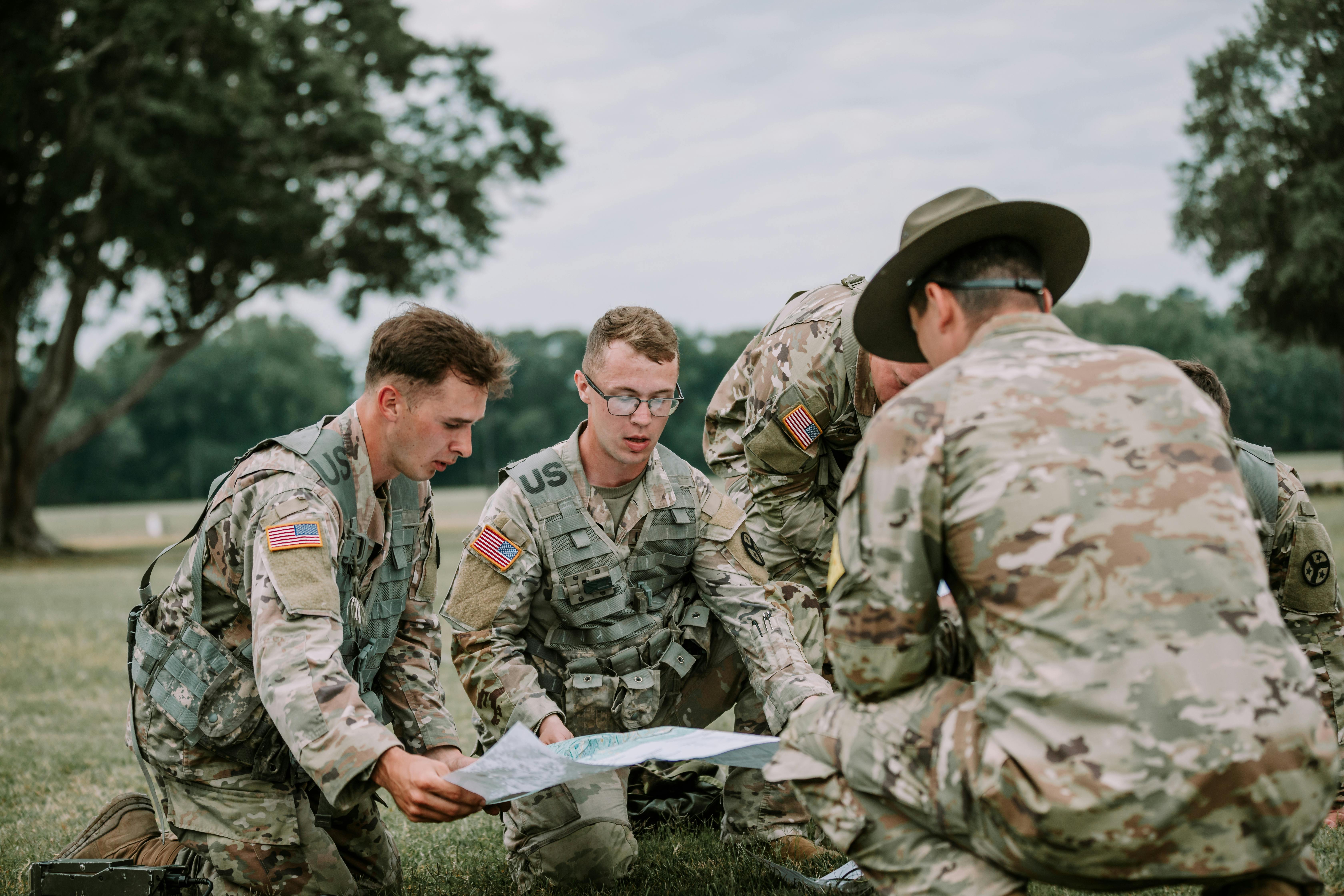 us soldiers in military uniforms sitting around map