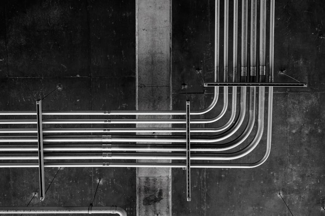 A black and white photo of pipes and wires