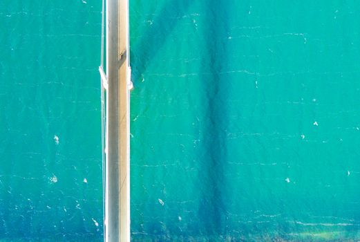 An aerial shot of a bridge crossing vibrant turquoise water. Perfect for travel and architecture themes.