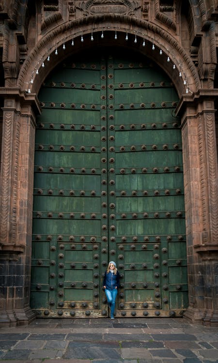 A person standing in front of a large green door