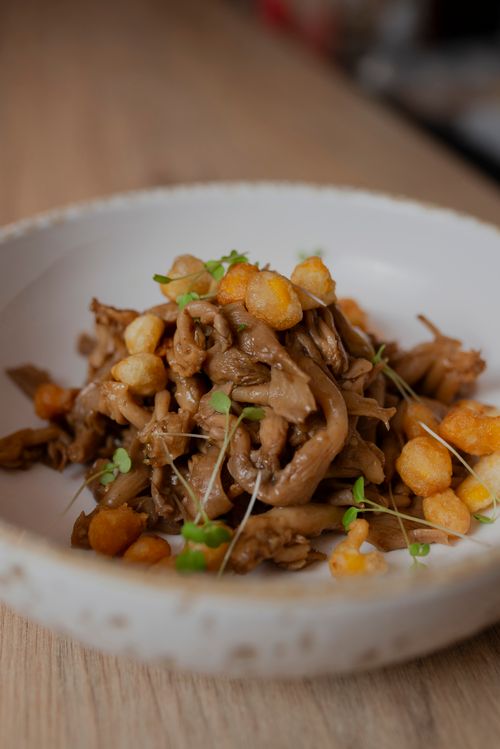 Free Close-up of a gourmet dish featuring sautéed mushrooms and crispy croutons garnished with microgreens. Stock Photo