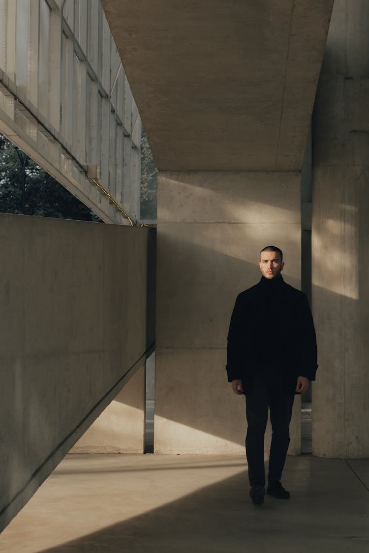 A Man Wearing All Black Standing In The Corner