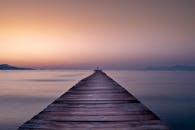 木制码头通往平静的大海的宁静日出场景，非常适合平静的反思