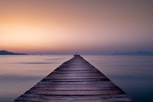 宁静的日出场景中，木制码头延伸向平静的大海，非常适合平静的反思