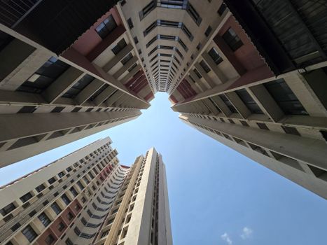 Dramatic upward view of modern skyscrapers against a clear blue sky in Pune, India.