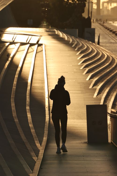 Silhouette of Woman Walking on a Street During Sunset · Free Stock Photo