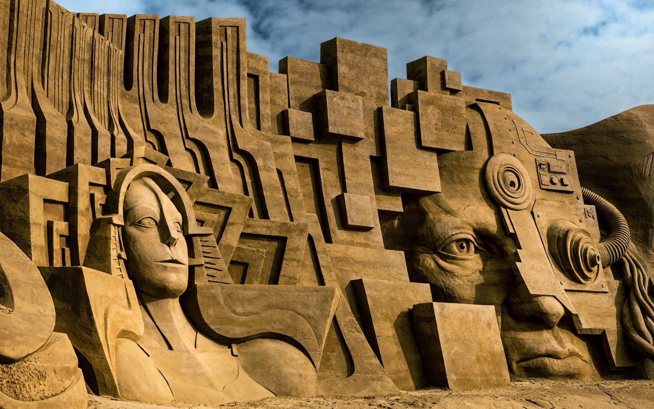 stunning sand sculptures depicting abstract art and human figures in r