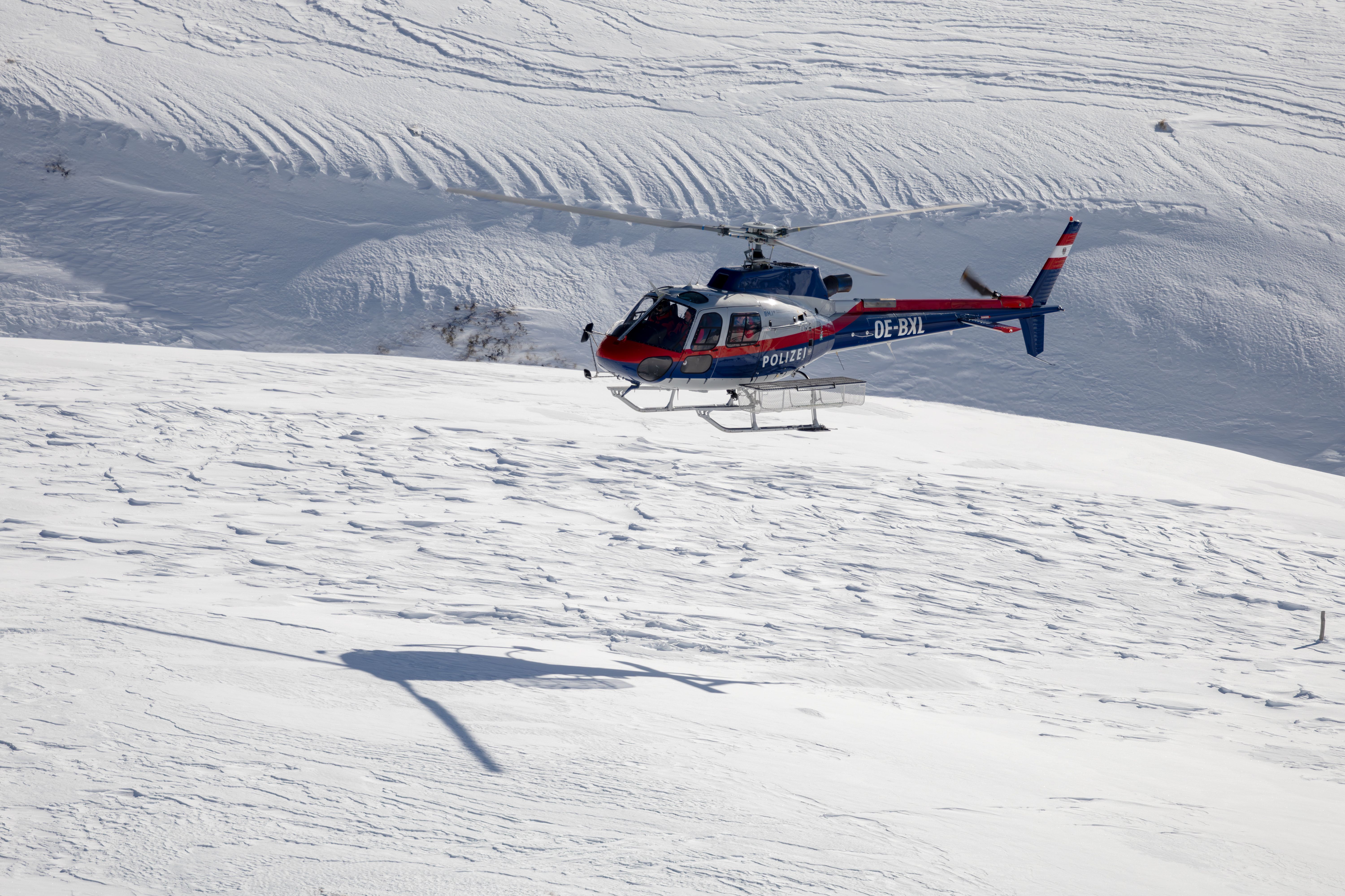 Mentőhelikopter havas alpesi hegyek felett