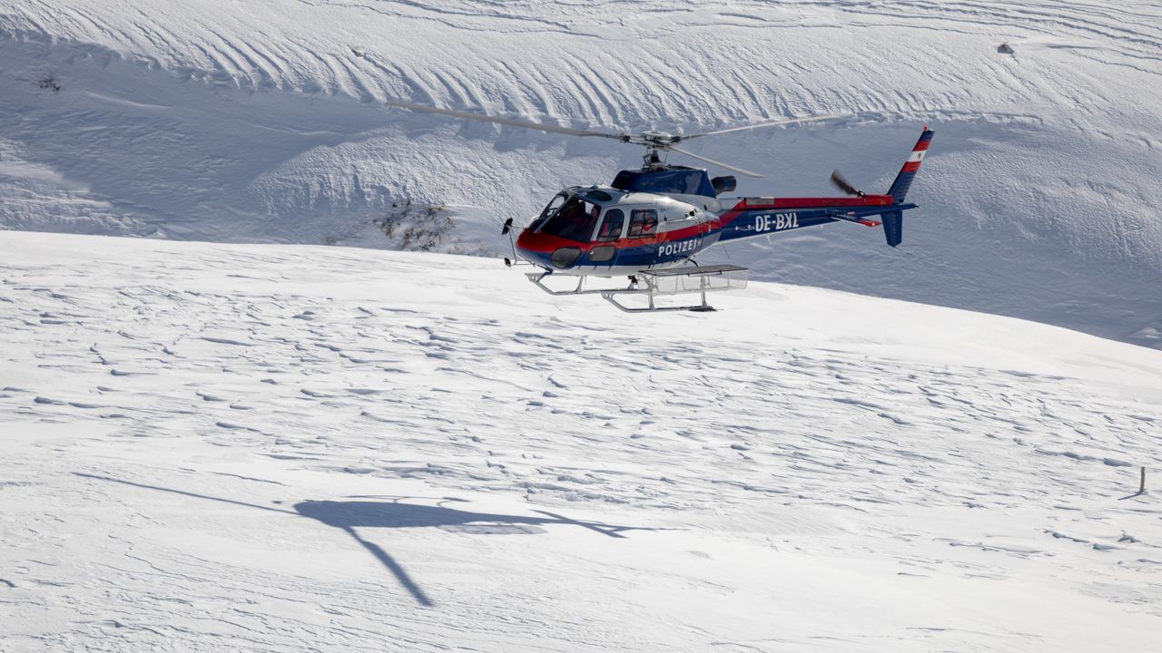 Mentőhelikopter havas alpesi hegyek felett