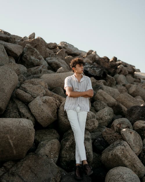 Man in Shirt Standing with Arms Crossed on Rocks