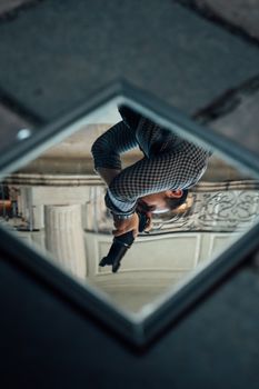 A creative shot of a photographer reflected in a mirror, capturing an elegant architectural background.