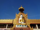 装饰精美的寺庙入口处，一尊华丽的金色佛像矗立在光天化日之下