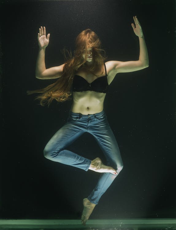 бесплатная Женщина в черном бюстгальтере и синих джинсах под водой Стоковое фото