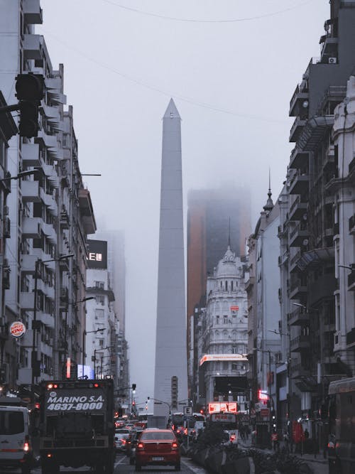 A tall obelisk in the foggy city